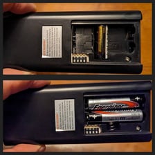 An AAA battery beside a television remote control
