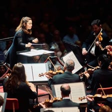A conductor leading musicians at a fast tempo