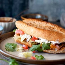 A Mexican torta sandwich made with a bolillo roll and savory fillings
