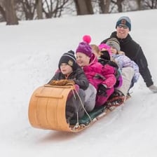A wooden toboggan resting on snow.