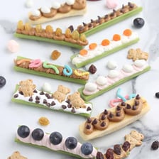 Celery sticks with peanut butter and raisins arranged as ants on a log