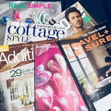 Several printed magazine editions stacked together.