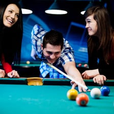 A skilled player lining up a shot on a pool table.