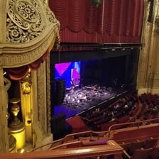 A theater’s loge seating section overlooking the stage.