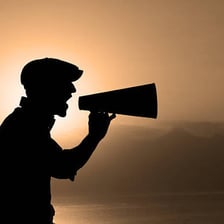 A person calling loudly toward someone far away