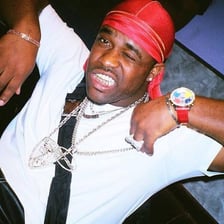 A hip-hop performer wearing a do-rag as a head covering.