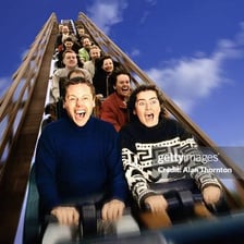 A person cheering during a thrilling roller-coaster ride
