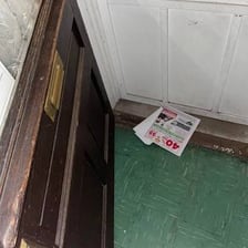 An envelope being inserted through a mail slot