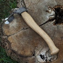 A handheld woodworking adz with a curved cutting blade.