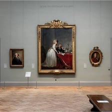 Paintings displayed on the walls of an art gallery.