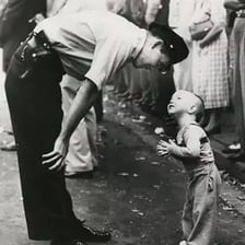 A child standing on tiptoes to see a parade.