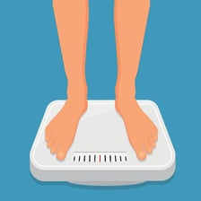 A person standing on a bathroom scale with the weight increasing