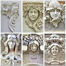 A decorative architectural mascaron depicting a carved face.