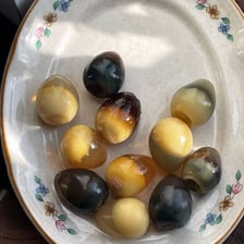 Preserved century eggs prepared by a traditional curing process