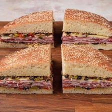 A sliced muffuletta sandwich showing ham and other fillings