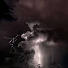 A thunderstorm with lightning beneath dark clouds.