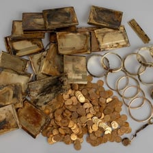 Gold coins and jewelry representing wealth