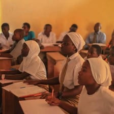 A school student studying at a classroom desk.