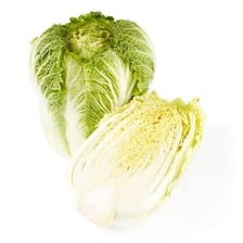 A whole napa cabbage showing its pale leaves and elongated shape.