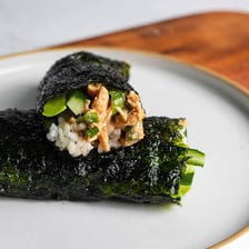 A sliced tuna sushi roll wrapped in dark nori seaweed