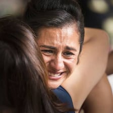 A person wiping tears from their eyes during an emotional moment