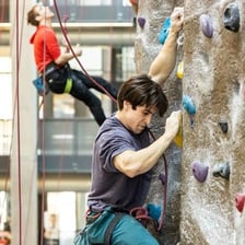 A person making an effort to climb a rock wall