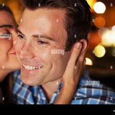 A couple sharing a brief kiss.