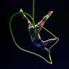 An aerial acrobat performing a stunt above the ground