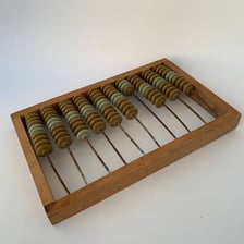 A traditional wooden abacus with rows of counting beads.