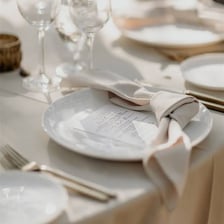 A table setting with a folded cloth napkin beside a plate.