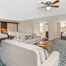 A spacious hotel suite with a living area and bedroom
