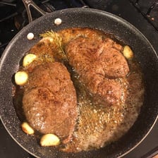 A steak with a browned, crispy crust from pan-searing.