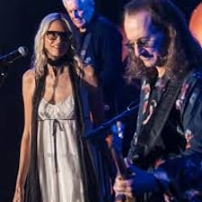 Aimee Mann performing onstage with a guitar