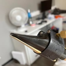 A saxophone mouthpiece with a reed attached.