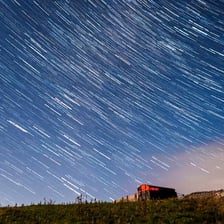 Bright meteors streaking across a dark night sky.