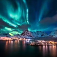 Green and purple aurora borealis lights across a dark sky.