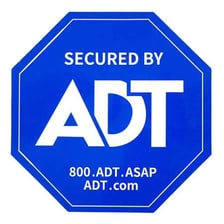 An ADT home-security sign beside a house