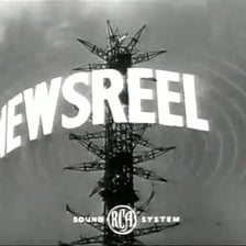 A vintage newsreel scene showing a location-and-date dateline at the start of a report.