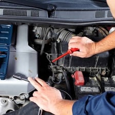 A mechanic servicing a car engine.