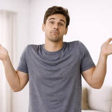 A person shrugging with a resigned expression