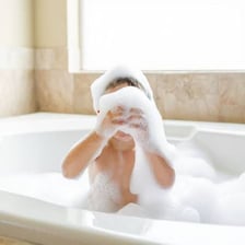 A bathtub filled with foamy bath bubbles