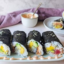 A sliced maki sushi roll wrapped in dark nori seaweed.