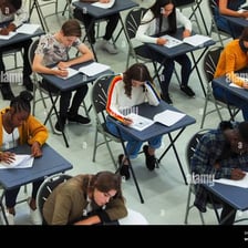A student taking a written exam in a classroom