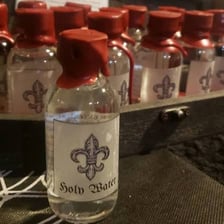 A small vial labeled or used as holy water in vampire folklore.