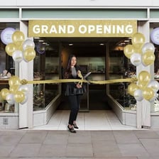 A storefront grand-opening ceremony with a ribbon cutting