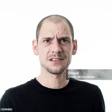 A person pausing with a thoughtful, puzzled expression.