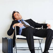 A sleepy person beginning to nod off in a chair.