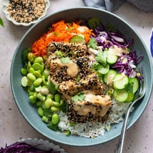Sesame seeds beside a bowl of tahini.