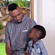 A father standing with his young son.