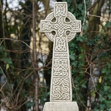 A carved stone Celtic cross with a ring around its center